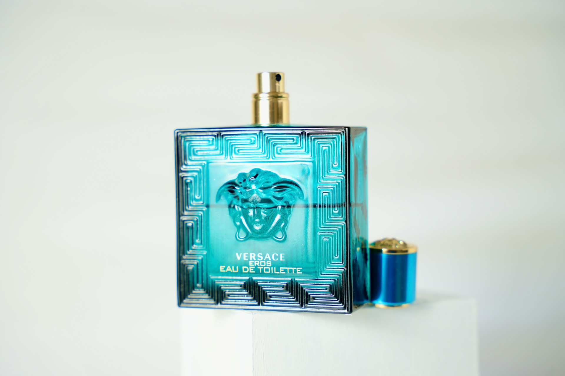 a bottle of perfume sitting on top of a white pedestal